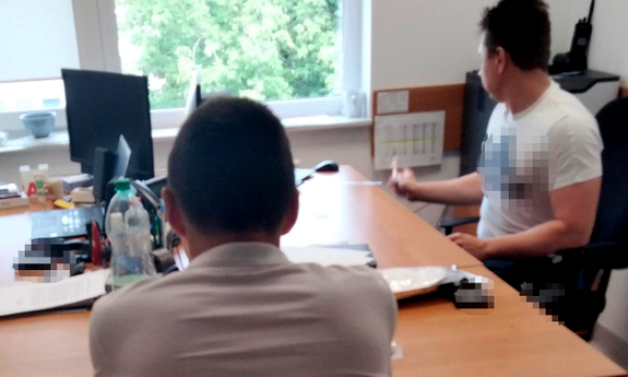 policjant z zatrzymanym mężczyzną podczas przesłuchania