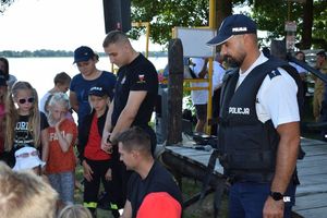 Policjant i strażacy z uczestnikami kolonii.