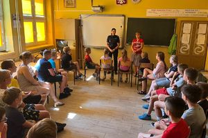 Policjantka rozmawia z grupą kolonistów.