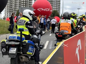 Policjant na motocyklu podczas zabezpieczania Tour de Pologne i kibice oglądający wyścig