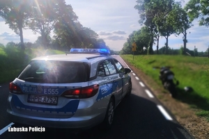 policyjny radiowóz, na poboczu drogi stoi skuter