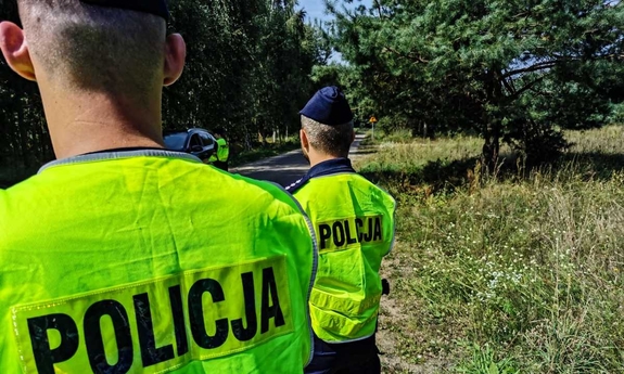 dwaj policjanci stoją na poboczu drogi