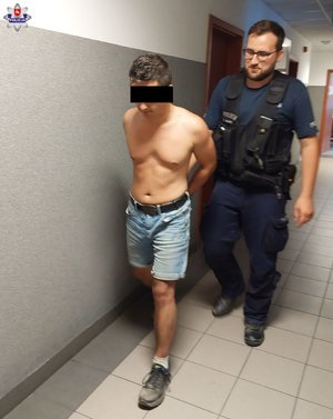 policjant prowadzi zatrzymanego mężczyznę