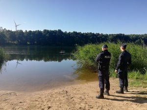 policjanci na brzegu zbiornika wodnego