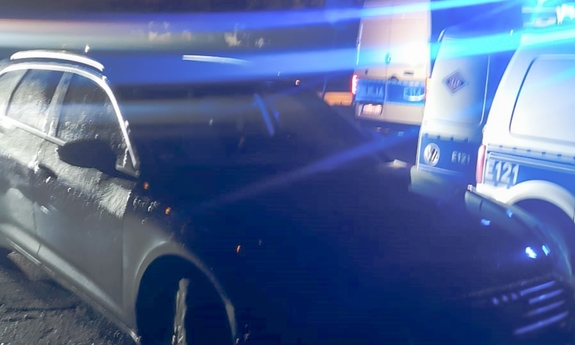 Radiowozy na sygnałach błyskowych przy rozbitym pojeździe audi