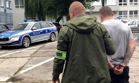 policjant prowadzi zatrzymanego mężczyznę