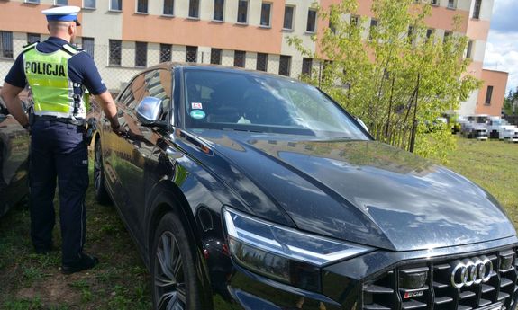 Umundurowany policjant stoi koło Audi SQ-8