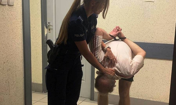 umundurowana policjantka z zatrzymanym mężczyzną