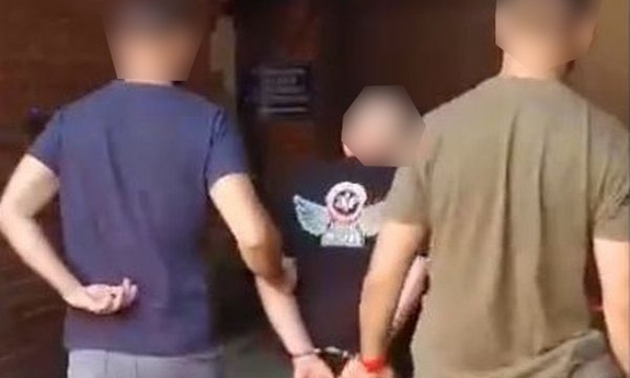 policjanci prowadzą zatrzymanego mężczyznego