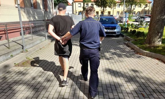Policjant prowadzi zatrzymanego