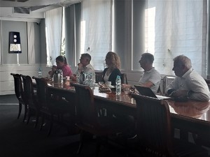 Grupa trzech mężczyzn i dwóch kobiet siedząca przy stole prezydialnym