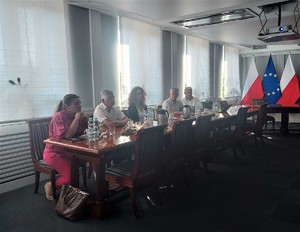 Grupa trzech mężczyzn i dwóch kobiet siedząca przy stole prezydialnym