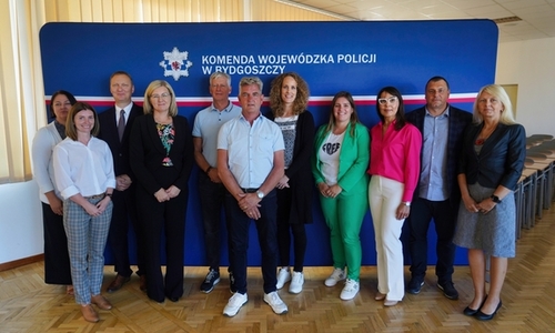 Zdjęcie grupowe przy ściance Komendy Wojewódzkiej Policji w Bydgoszczy