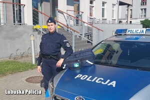 umundurowana policjantka stoi obok radiowozu