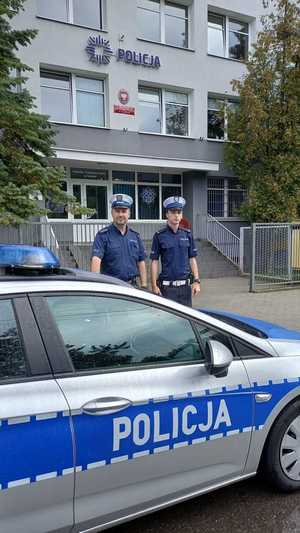 umundurowani policjanci stoją pod budynkiem jednostki policji