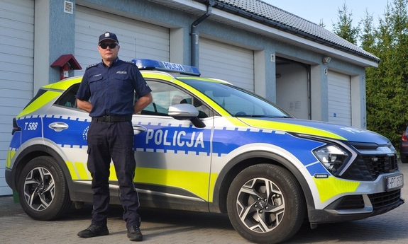 asp. szt. Dawid Zieliński stoi przy radiowozie