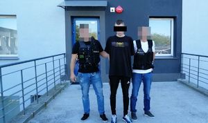 dwaj policjanci z zatrzymanym mężczyzną