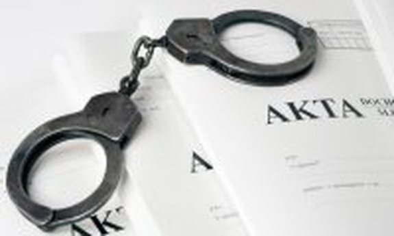 kajdanki leżą na aktach sprawy