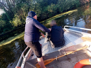 Policjant z uratowanym mężczyzną na łodzi