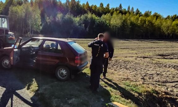 Policjanci pomagają wyciągnąć samochód z rowu