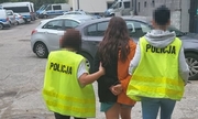 dwie policjantki prowadza zatrzymaną kobietę