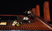 Policjanci i strażacy na dachu pomagają mężczyźnie