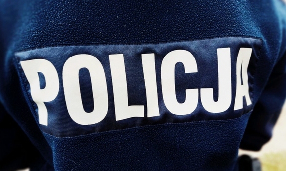biały napis policja na plecach granatowej kurtki policjanta