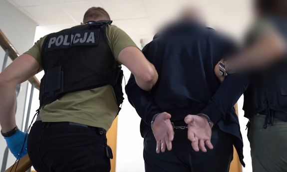 Policjanci prowadzą zatrzymanego