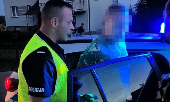 policjant z zatrzymanym przy radiowozie