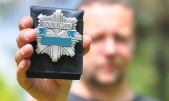 Policjant trzymający legitymację służbową