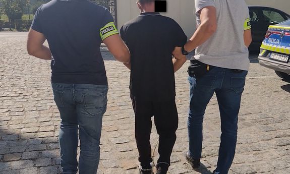 Policjanci prowadzą zatrzymanego