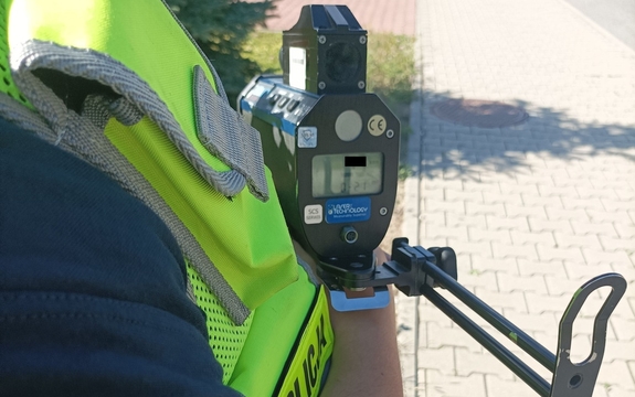 Zdjęcie przedstawiające policjanta ruchu drogowego trzymającego radar