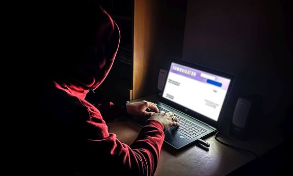 Mężczyzna siedzi przed komputerem i pisze coś na komunikatorze