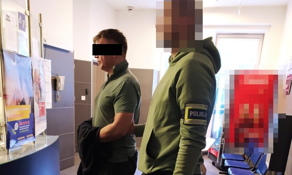 policjant prowadzi zatrzymanego mężczyznę