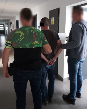 dwaj nieumundurowani policjanci z zatrzymanym mężczyzną