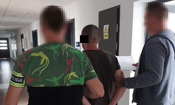 dwaj nieumundurowani policjanci z zatrzymanym mężczyzną