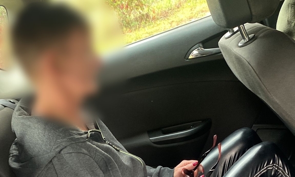 zatrzymana kobieta siedzi na tylnym siedzeniu w samochodzie