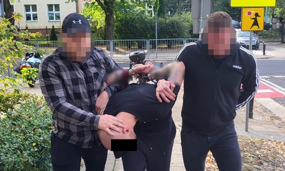 Zatrzymany przez policjantów mężczyzna podejrzany o oszustwo prowadzony przez dwóch nieumundurowanych policjantów