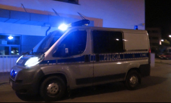 radiowóz z włączonymi sygnałami świetlnymi stojący przed szpitalem