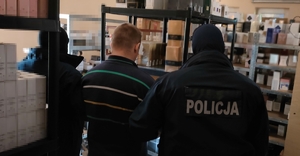 Policjant z zatrzymanym mężczyzną w magazynie