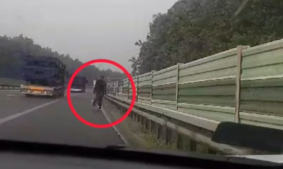 Mężczyzna idzie autostradą