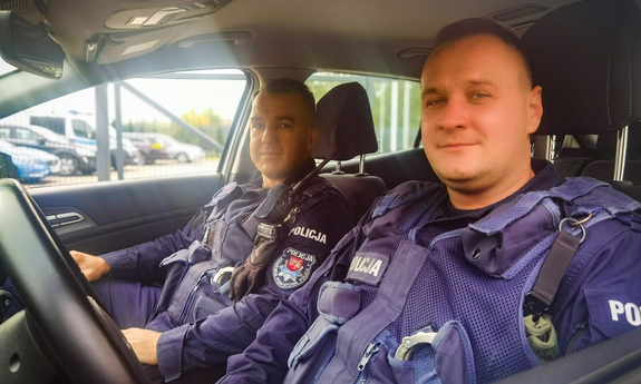dwaj policjanci siedzą w radiowozie