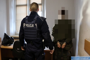 Policjant z zatrzymaną osobą skutą w kajdanki