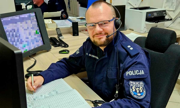 dyżurny Adrian Skowroński siedzi przy swoim stanowisku służby