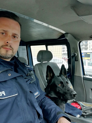 zdjęcie policjanta z psem, który odnalazł kobietę