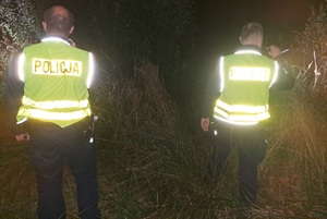 dwaj policjanci z latarkami w dłoniach w trakcie poszukiwań