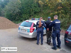 Policjanci prowadzą zatrzymanego do radiowozu