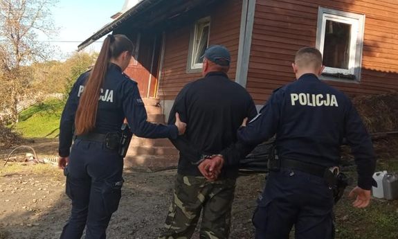 Policjanci prowadzą zatrzymanego