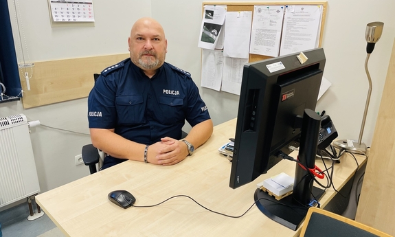 policjant siedzi przy biurku