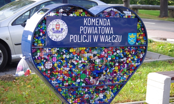metalowe serce napełnione nakrętkami w tle trawa